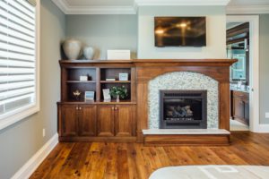 walnut fireplace surround and wallunit with bookcases in master bedroom